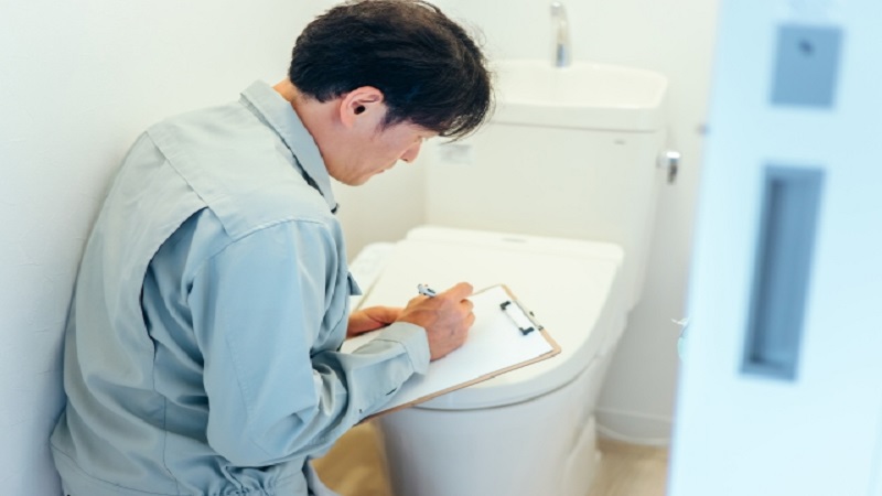 トイレを点検する修理業者